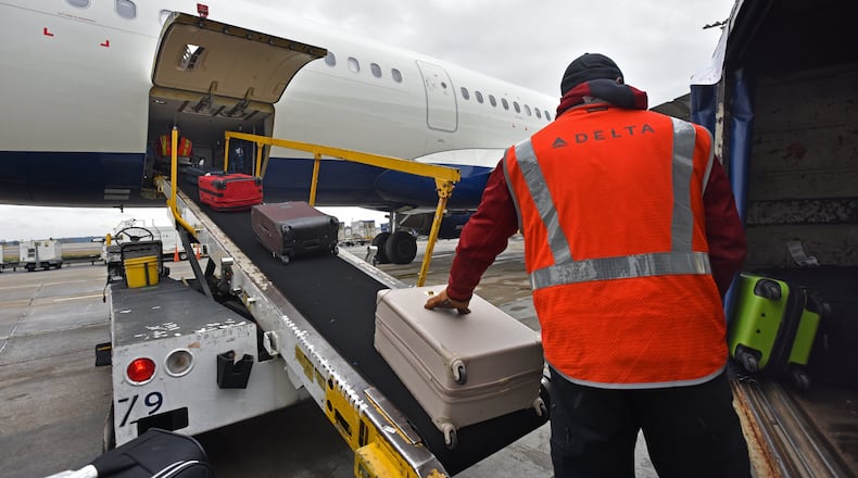 Delta baggage crew Danny Carpenter loads bags at Hartsfield-Jackson International Airport on Wednesday, February 27, 2019.  HYOSUB SHIN / HSHIN@AJC.COM