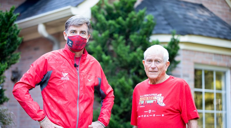 Rich Kenah, executive director of Atlanta Track Club, poses for a photo with Bill Thorn in Tyrone, Georgia, on Tuesday, October 13, 2020. Bill Thorn was presented the t-shirt for the annual Peachtree Road Race on Tuesday by the Atlanta Track Club. (Photo/Rebecca Wright for the Atlanta Journal-Constitution)