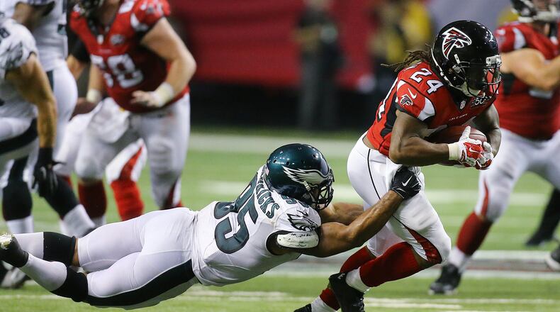 Falcons running back Devonta Freeman drags Eagles’ Mychal Kendricks along on a run during Monday’s game. Photo by Curtis Compton / ccompton@ajc.com