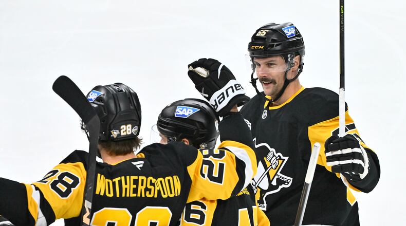 Pittsburgh's Parker Wotherspoon is congratulated by teammates Blake Lizotte and Erik Karlsson after his 1-0 goal during the NHL Global Series hockey game between the Pittsburgh Penguins and the Nashville Predators in Stockholm, Sweden, Sunday, Nov. 16, 2025. (Claudio Bresciani/TT News Agency via AP)