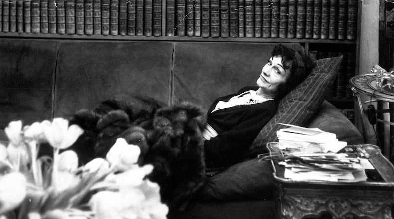Gabrielle "Coco" Chanel, back in the fashion world after a lapse of 15 years, relaxes in her book-lined studio above her Paris salon April 21,1954. (AP photo)