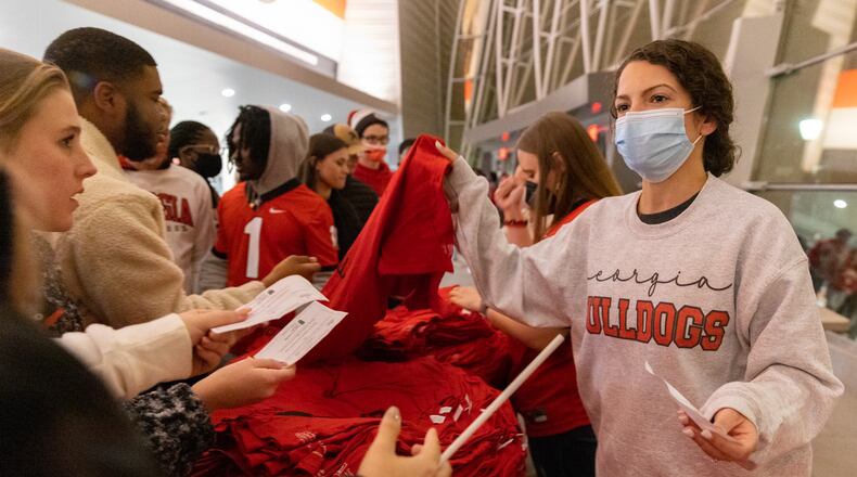 Georgia Bulldogs fans receive shirts at Stegeman Coliseum on the University of Georgia campus in Athens ahead of a watch party for the College Football Playoff national championship game held Monday. Many of Georgia’s largest public universities are reporting a significant increase in new COVID-19 cases as classes resume this week. (Nathan Posner for The Atlanta Journal-Constitution)