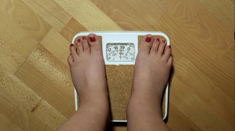 LONDON, ENGLAND - SEPTEMBER 2006: An anonymous woman, 42, on the scales before her weight loss surgery. The scales stop at 19 stone, but she weighs nearly 20 stone (126kg) and is severely obese. She hopes to lose around a third of her weight by having a gastric band fitted. (Photo by Tina Stallard/Getty Images)