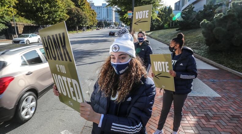 November 3, 2020 Atlanta: Georgia Tech basketball players front to back - Lorela Cubaj, Aixa Wone and Nerea Hermosa held signs wanting motorists to honk on 10th street on Tuesday, Nov. 3, 2020 outside the McCamish Pavilion voting precinct at Georgia Tech. Voters lined up outside polling places Tuesday morning to be among the first to cast their votes on a crucial Election Day. It’s expected to be the biggest day of voting in Georgia, with turnout reaching as high as 2 million. Another 3.9 million people already cast early or absentee ballots. Some told The Atlanta Journal Constitution that they expect social unrest whether Biden or Trump wins the election. (John Spink / John.Spink@ajc.com)