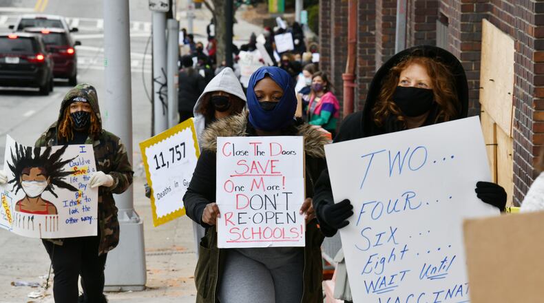 On Saturday, Jan. 16, APS teachers and supporters holding signs march around the Atlanta Public Schools headquarters to push APS to delay reopening school buildings because they believe it’s not safe to reopen because of the surge in coronavirus cases. (Photo: Hyosub Shin / Hyosub.Shin@ajc.com)