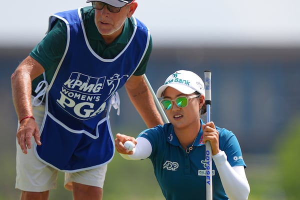 Minjee Lee, right, and her caddie Michael Paterson strategize for a putt on the first green during the final round of the Women's PGA Championship golf tournament Sunday, June 22, 2025, in Frisco, Texas. (AP Photo/LM Otero)
