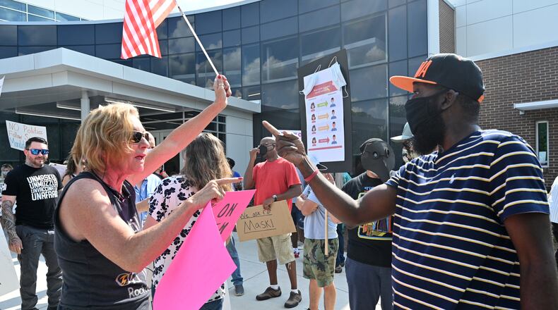 August 12, 2021 Marietta - A protester (right) demanding mask-mandate confronts a counter-protester as they rally at the parking lot of Cobb County School District on Thursday, August 12, 2021. Cobb County schools began the 2021-22 school year with a rule that made mask wearing optional for students and staff. (Hyosub Shin / Hyosub.Shin@ajc.com)