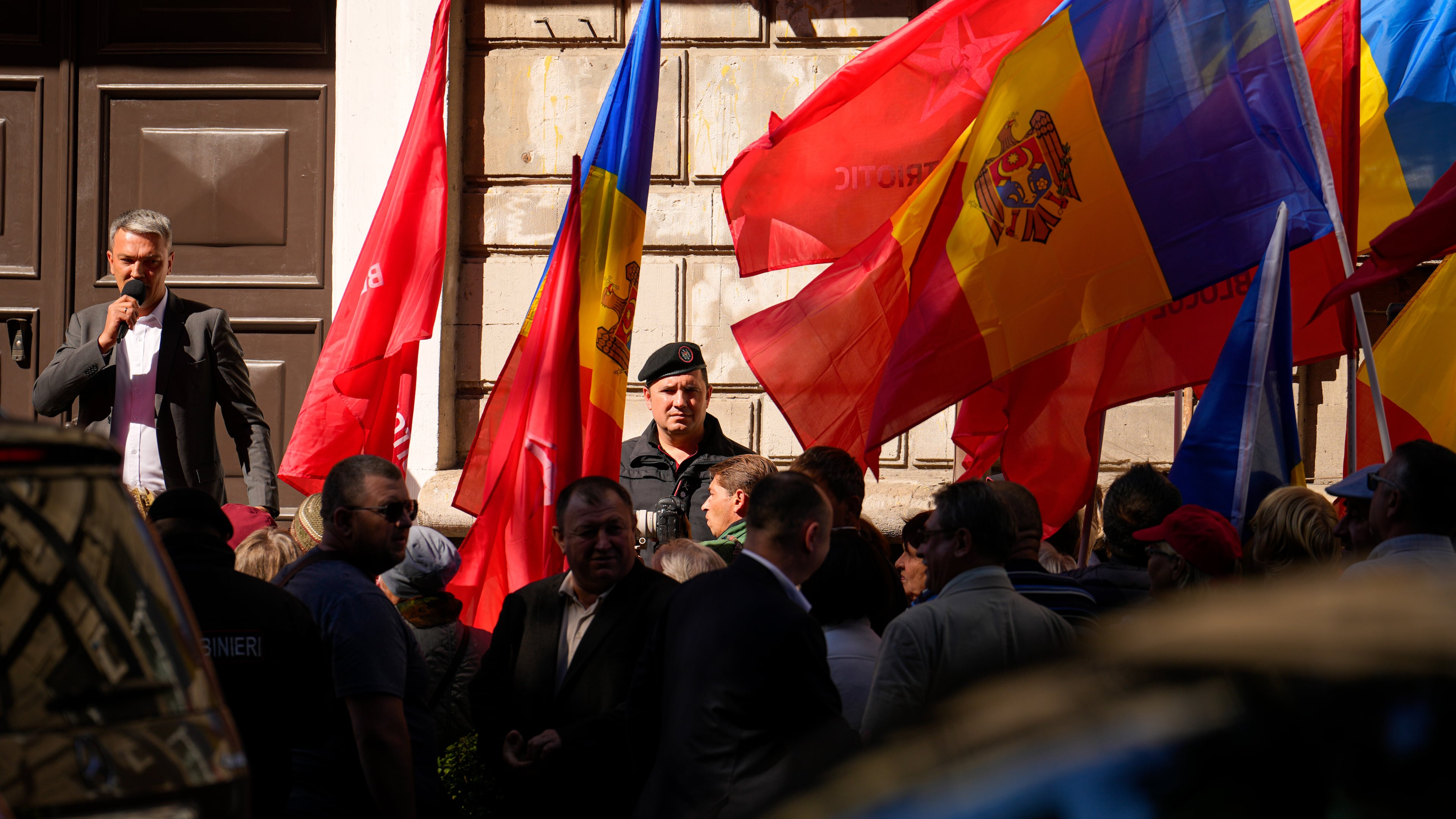A gendarme watches as supporters hold flags at a protest rally of the Russia-friendly Patriotic Electoral Bloc in Chisinau, Moldova, Friday, Sept. 26, 2025, ahead of parliamentary elections taking place on Sept. 28. (AP Photo/Vadim Ghirda)