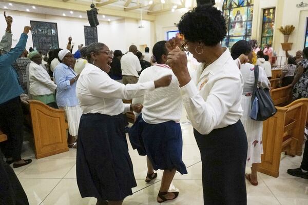 Suzie Aristide, center, and other volunteers dance at the conclusion of a more than four-hour-long Lent revival Mass at Notre Dame d'Haiti Catholic church, early March 30, 2025, in Miami. (AP Photo/Giovanna Dell'Orto)