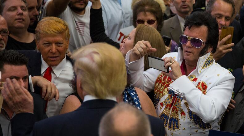 An attendee dressed in costume as Elvis takes photos of Donald Trump, a Republican presidential hopeful, as Trump greets the line after speaking at a campaign event at South Point Arena in Las Vegas, Feb. 22, 2016. (Ruth Fremson/The New York Times)