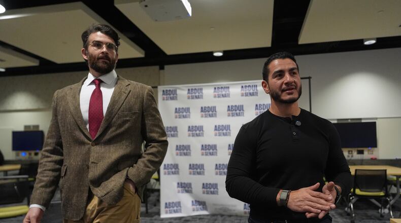 Hasan Piker, left, listens as Abdul El-Sayed, a progressive candidate in the Democratic primary for U.S. Senate in Michigan, speaks in a green room before a campaign rally, Tuesday, April 7, 2026, at the University of Michigan in Ann Arbor, Mich. (AP Photo/Julia Demaree Nikhinson)