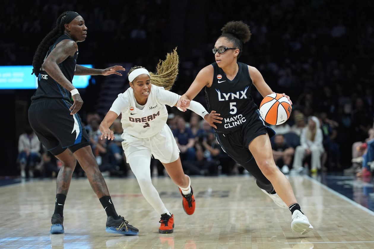 Minnesota Lynx guard Olivia Miles (5) works toward the basket while defended by Atlanta Dream guard Jordin Canada (3) during the first half of a WNBA basketball game Wednesday, May 27, 2026, in Minneapolis. (AP Photo/Abbie Parr)