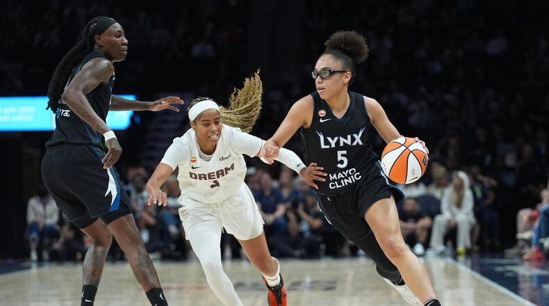Minnesota Lynx guard Olivia Miles (5) works toward the basket while defended by Atlanta Dream guard Jordin Canada (3) during the first half of a WNBA basketball game Wednesday, May 27, 2026, in Minneapolis. (AP Photo/Abbie Parr)