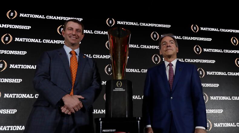 Clemson coach Dabo Swinney and Alabama coach Nick Saban pose with the championship trophy during a news conference for the College Football Playoff on Sunday, Jan. 8, 2017, in Tampa, Fla. (AP Photo/David J. Phillip)