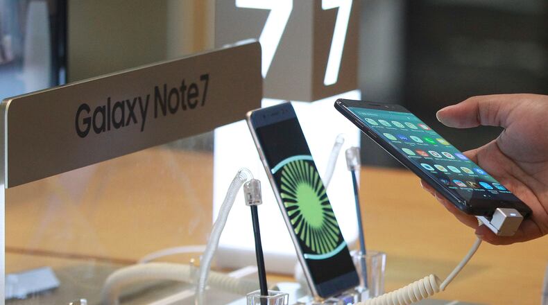 A visitor tries out a Samsung Electronics Galaxy Note 7 smartphone at the company's shop in Seoul in Seoul, South Korea, Monday, Oct. 10, 2016. Samsung Electronics has temporarily halted production of its Galaxy Note 7 smartphones, South Korea's Yonhap news agency reported Monday, following reports that replacements for the fire-prone phones were also overheating. (AP Photo/Ahn Young-joon)