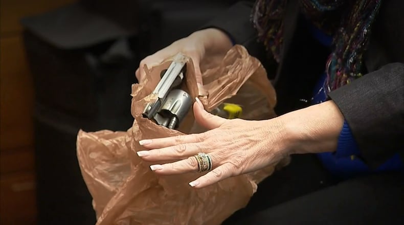 Witness Dani Jo Carter demonstrates how she saw Tex McIver wipe the smoke coming from the gun after it fired. The demonstration was part of Carter's testimony during the Tex McIver murder trial on March 21, 2018 at the Fulton County Courthouse. (Channel 2 Action News)