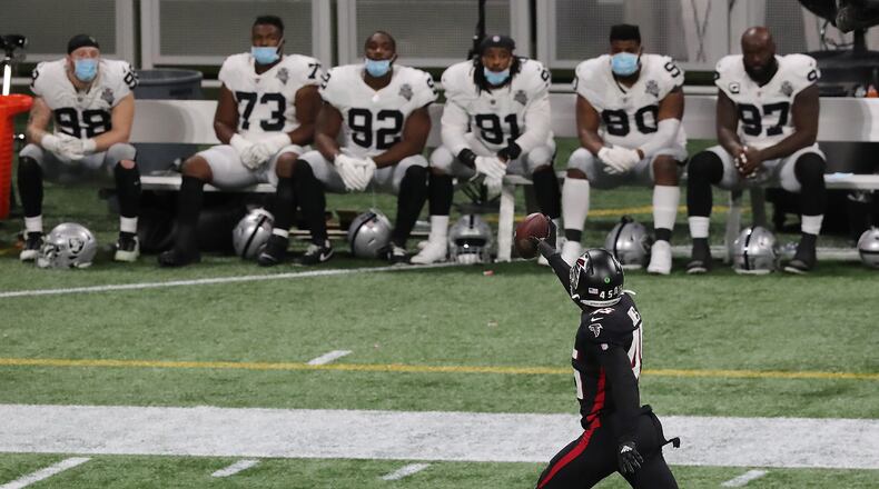 The Las Vegas Raiders' bench looks on as Atlanta Falcons linebacker Deion Jones intercepts a Derek Carr pass and returns it for a touchdown for a 23-3 lead during the third quarter on Sunday, Nov. 29, 2020, in Atlanta, Georgia. The Falcons beat the Raiders 43-6. (Curtis Compton/Atlanta Journal-Constitution/TNS)