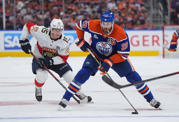 Edmonton Oilers' Leon Draisaitl (29) skates with the puck while being watched by Florida Panthers' Anton Lundell (15) during the second period in Game 2 of the NHL Stanley Cup Final, in Edmonton, on Friday, June 6, 2025. (Darryl Dyck/The Canadian Press via AP)