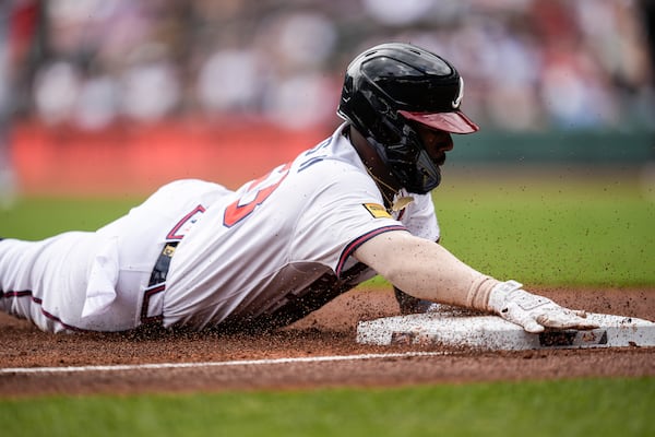 Atlanta Braves outfielder Michael Harris II (23) dives into third base safe against the St. Louis Cardinals in the first inning of a baseball game, Wednesday, April 23, 2025, in Atlanta. (AP Photo/Mike Stewart)