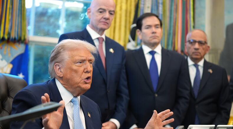 President Donald Trump answers questions from reporters during a meeting with the White House task force on the 2026 FIFA World Cup in the Oval Office of the White House, Monday, Nov. 17, 2025, in Washington, as FIFA President Gianni Infantino, Secretary of State Marco Rubio and FIFA senior adviser Carlos Cordeiro listen. (AP Photo/Evan Vucci)
