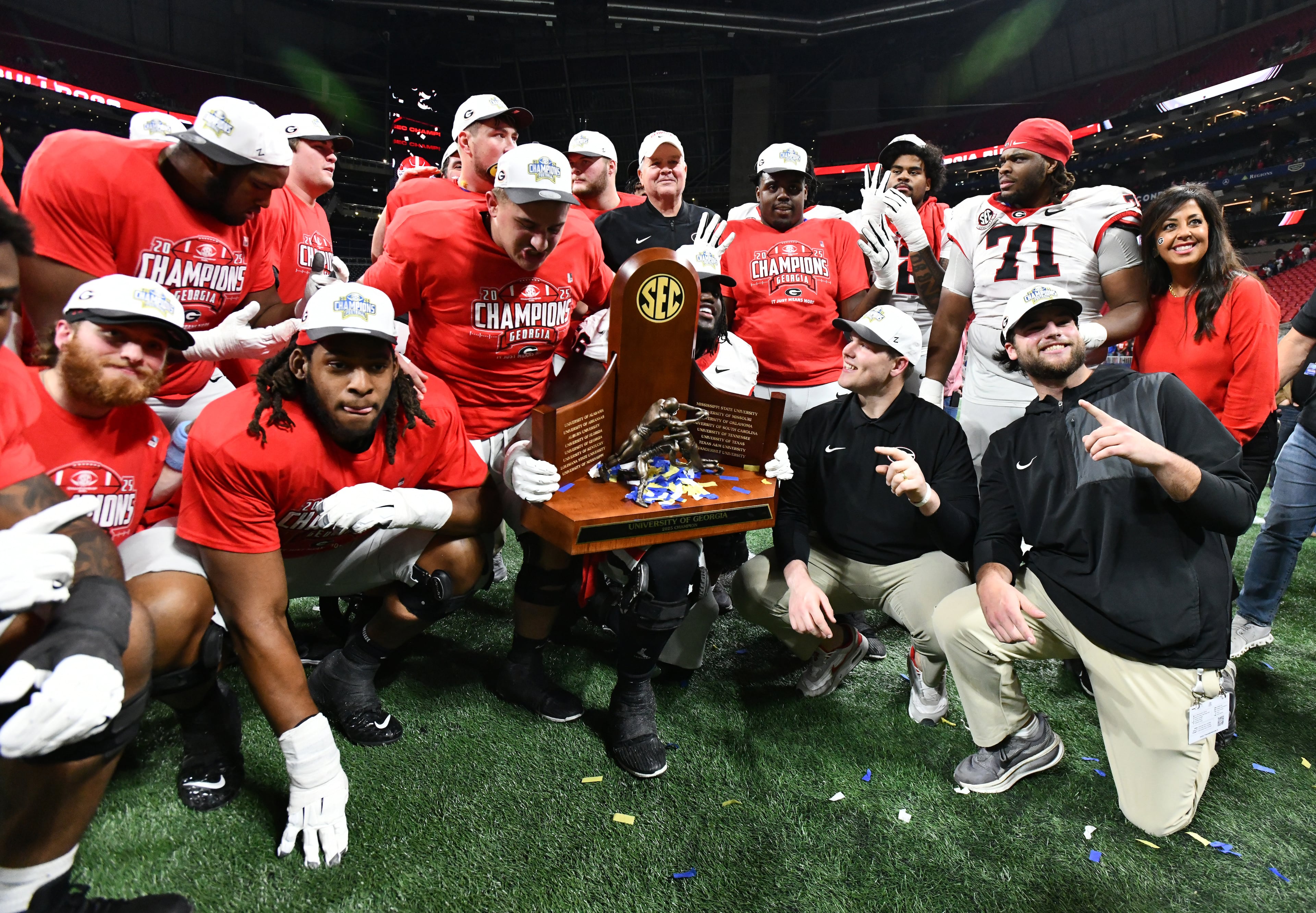Georgia players pose with the championship trophy as they celebrate after defeating Alabama 28-7 in the SEC Championship football game at the Mercedes-Benz Stadium, Saturday, December 6, 2025 in Atlanta. (Hyosub Shin / AJC)