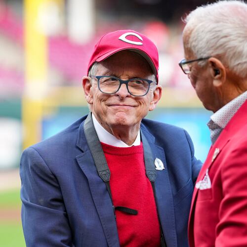 FILE - Hall of Fame broadcaster Marty Brennaman, right, speaks with Ohio Gov. Mike DeWine, left, during "Marty Brennaman Day" prior to a baseball game between the New York Mets and the Cincinnati Reds, Saturday, Sept. 6, 2025, in Cincinnati. (AP Photo/Jeff Dean, File)