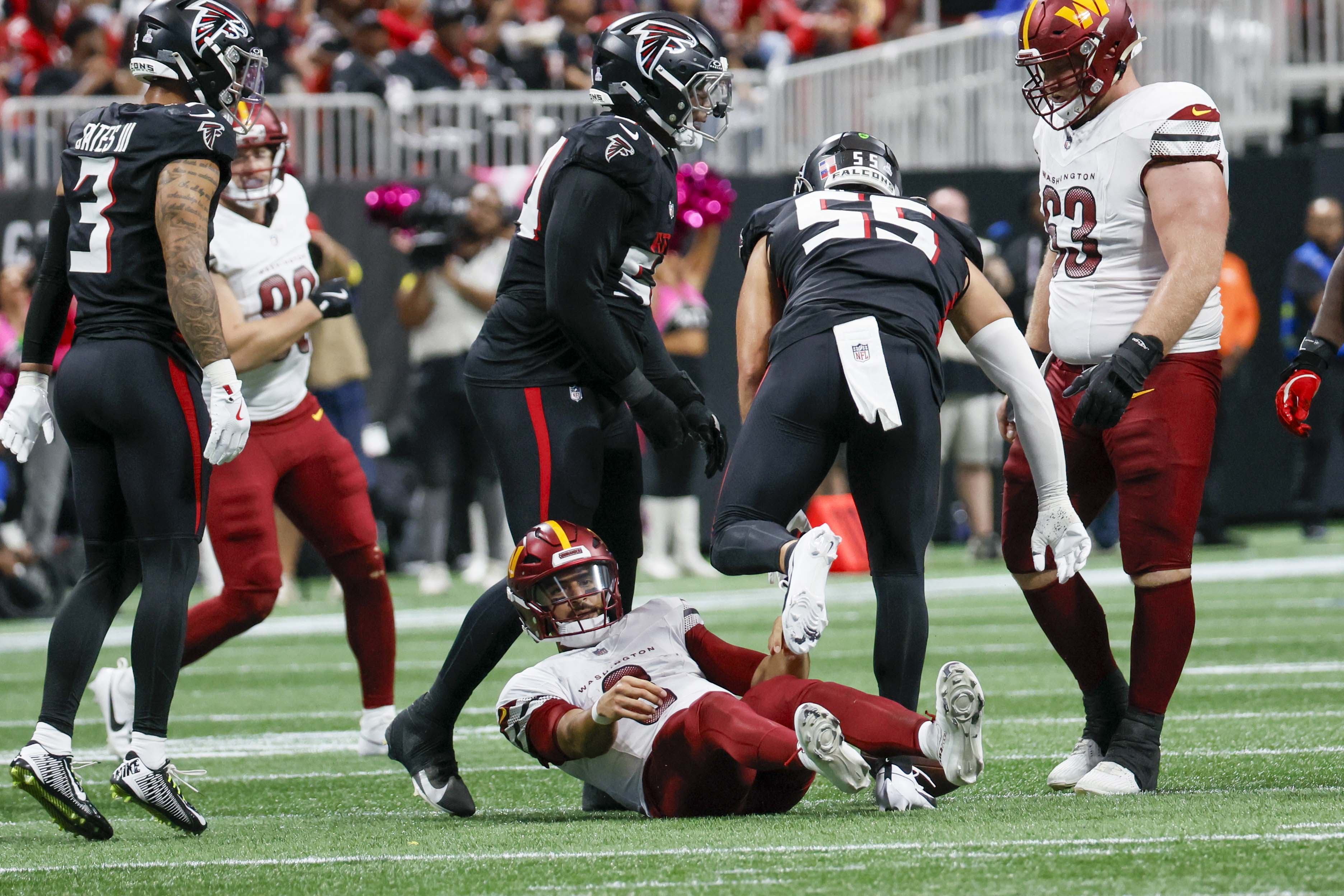 Washington Commanders quarterback Marcus Mariota lays on the ground after a sack by Atlanta Falcons linebacker Kaden Elliss during the second half of an NFL game at Mercedes-Benz Stadium in Atlanta on Sunday, September 28, 2025. (Miguel Martinez/AJC)