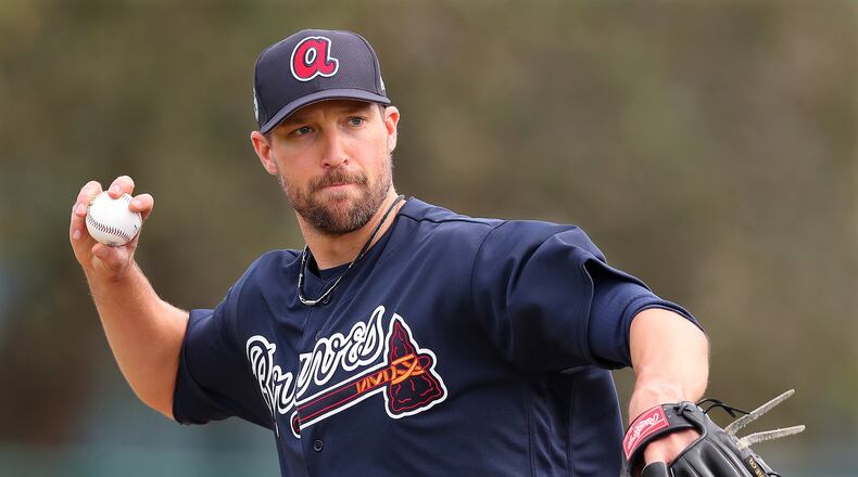 Jim Johnson throws to first during a pitcher’s fielding drill at spring training Wednesday. (Curtis Compton/ccompton@ajc.com)