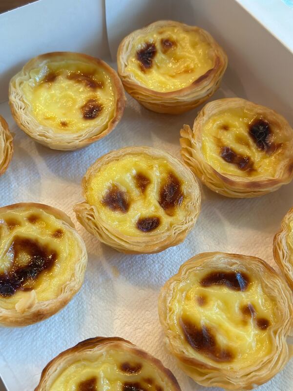 A box holding nine natas, which are small puff pastry shells filled with a carmelized egg custard.