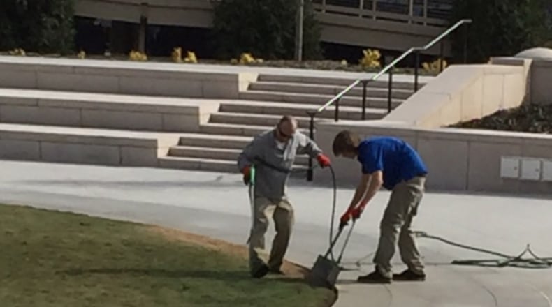 Workers finish up the Liberty Plaza dye job on Monday. (James Salzer/AJC Staff)