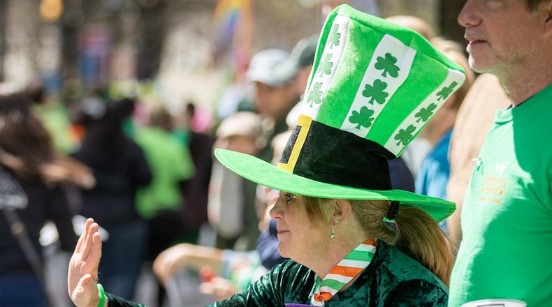 Kathy Workman waves as the Atlanta St. Patrick's Parade heads down Peachtree Street on Saturday, March 11, 2023. (Photo: Steve Schaefer / steve.schaefer@ajc.com)