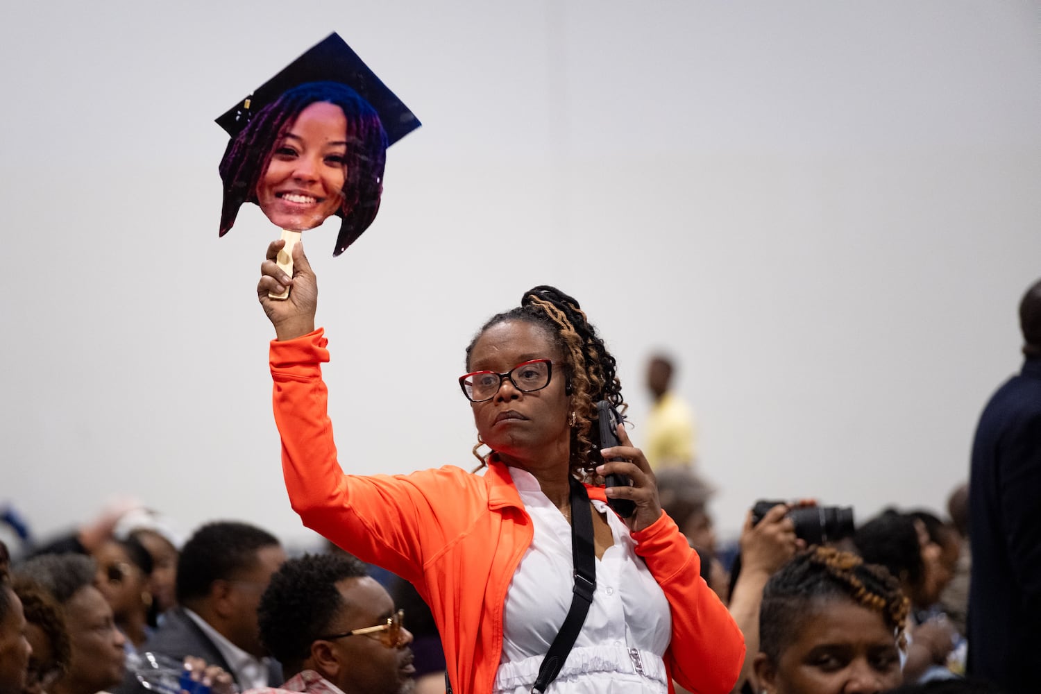 Dr. Tamika Thompson holds up a cutout of her daughter-in-law Daysia Sloan while holding seats for family before the Spelman College graduation ceremony at the Georgia International Convention Center in College Park on Sunday, May 18, 2025.   Ben Gray for the Atlanta Journal-Constitution
