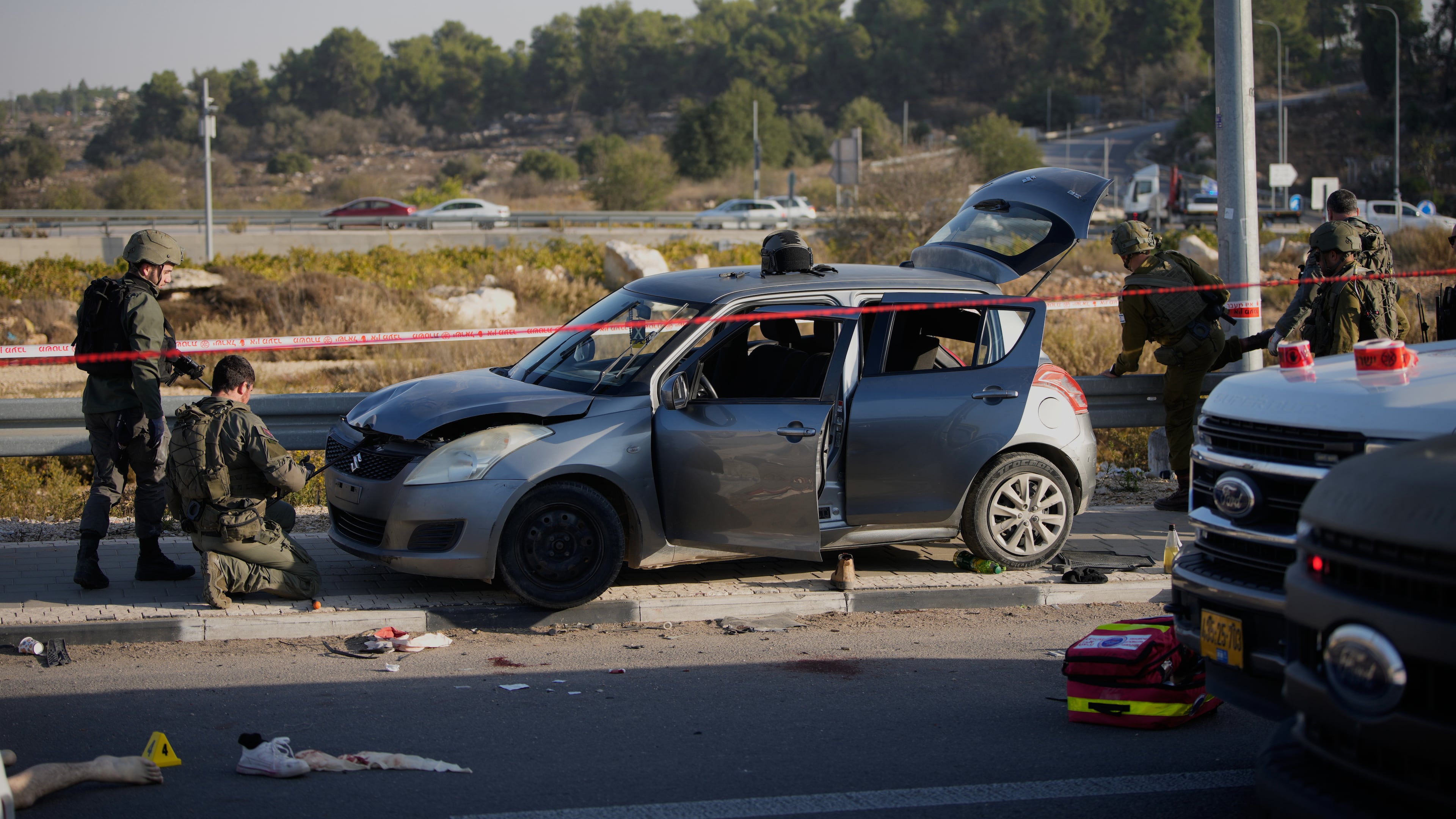 Members of Israeli security forces inspect the site of a ramming and stabbing attack near the West Bank Jewish settlement of Gush Etzion, Tuesday, Nov. 18, 2025. (AP Photo/Ohad Zwigenberg)