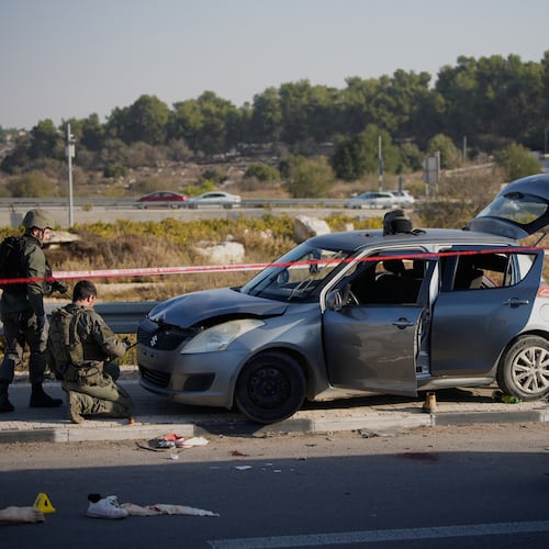 Members of Israeli security forces inspect the site of a ramming and stabbing attack near the West Bank Jewish settlement of Gush Etzion, Tuesday, Nov. 18, 2025. (AP Photo/Ohad Zwigenberg)