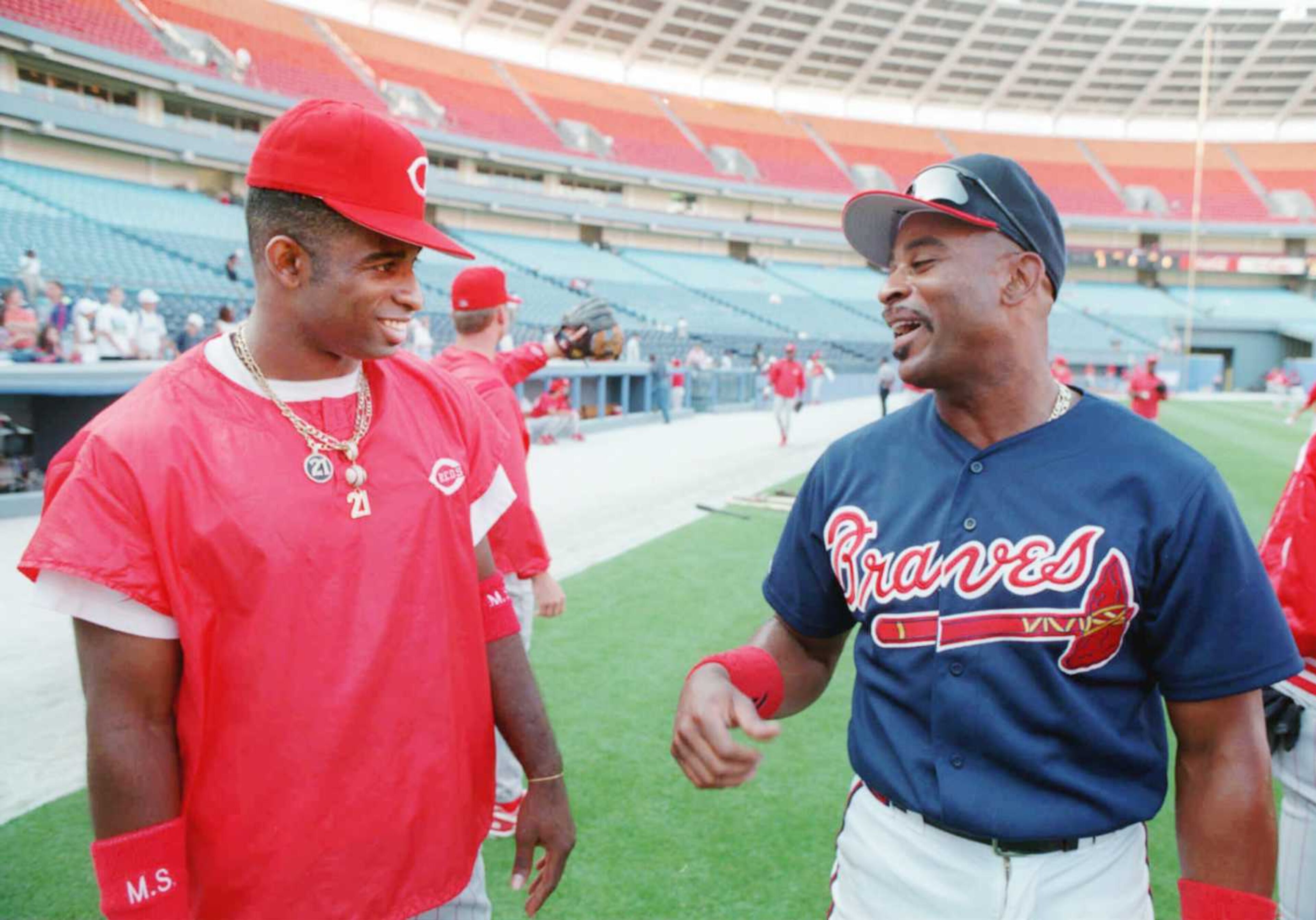 Former Brave Deion Sanders (left) chats with outfielder Dwight Smith before a game in May 1995.