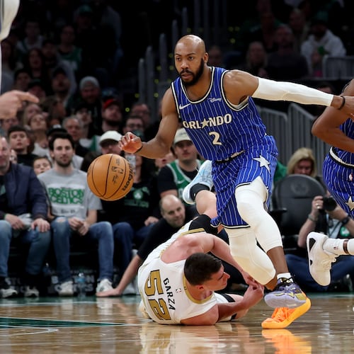 Boston Celtics forward Luka Garza (52) falls to the court as Orlando Magic guard Jevon Carter (2) and forward Jamal Cain (8) take control of the ball during the second half of an NBA basketball game, Sunday, April 12, 2026, in Boston. (AP Photo/Mark Stockwell)