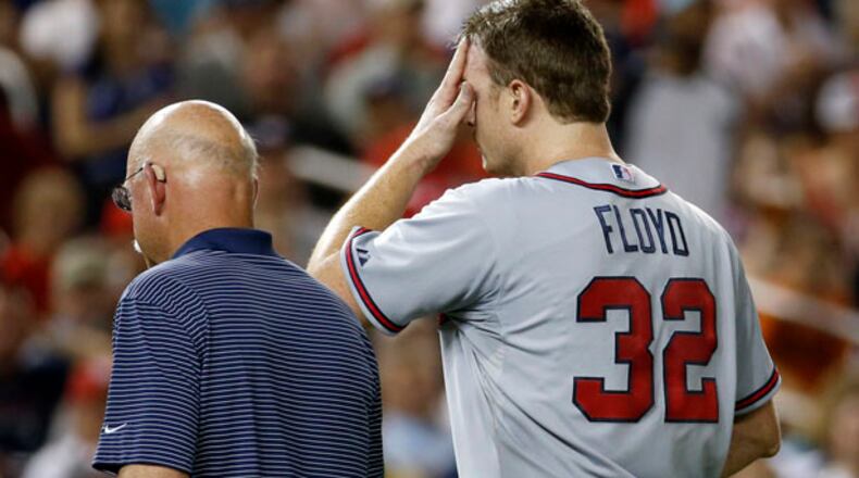 Atlanta Braves head athletic trainer Jeff Porter escorts Atlanta Braves starting pitcher Gavin Floyd off their field during the seventh inning of a baseball game against the Washington Nationals at Nationals Park Thursday, June 19, 2014, in Washington. The Braves won 3-0. Atlanta Braves right-hander Gavin Floyd left Thursday night's game against the Washington Nationals with an elbow injury in his ninth start since returning from Tommy John surgery. (AP Photo/Alex Brandon)