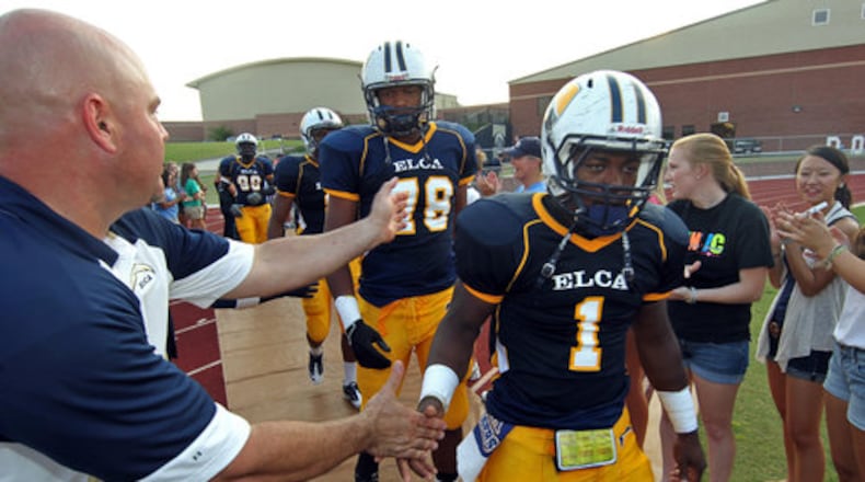 Eagle's Landing Christian Academy captains Isaac Rochell, center, and Keyante Green, right, are greeted by fans before their game against Briarwood Christian Friday night. Eagle's Landing Christian Academy has become a big-time player on the Class A football scene and opens the season as the state's top-ranked Class A team.