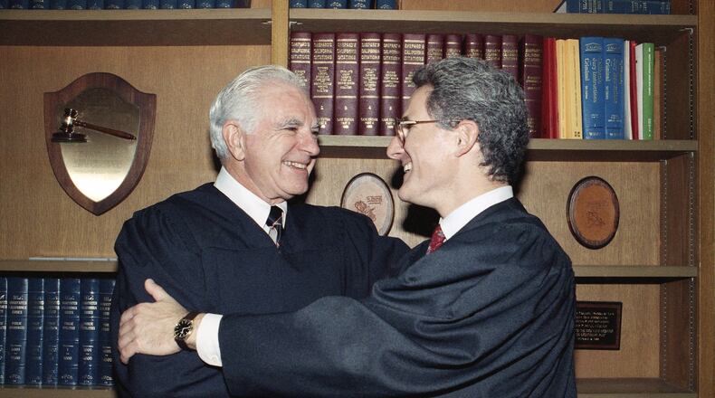 In this Friday, Oct. 13, 1989, file photo, retired Judge Joseph A. Wapner of TV's 'The People's Court' congratulates his son, Judge Frederick N. Wapner, right, as he was enrobed as a Municipal Court judge in Los Angeles. Wapner, who presided over "The People's Court" with steady force during the heyday of the reality courtroom show, has died. Wapner died at home in his sleep Sunday, Feb. 26, 2017, according to his son, David Wapner. (AP Photo/Nick Ut, File)