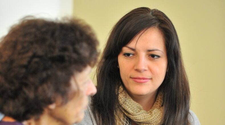 Stacy Soulimoitis (right) and her ailing mother, Eleni Soulimiotis, hold hands at their home in Tucker last week. HYOSUB SHIN / HSHIN@AJC.COM