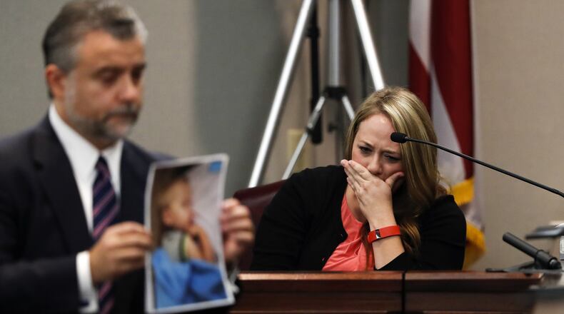 As defense attorney Maddox Kilgore holds up a photo of Cooper Harris for the jury on Monday, Leanna Taylor weeps on the witness stand in the background. (AP Photo/John Bazemore, Pool)