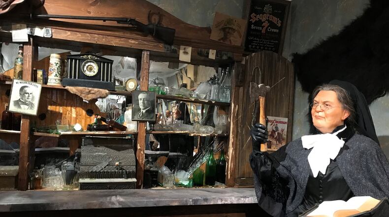 At the American Prohibition Museum in Savannah, a wax figure of Temperance Movement leader Carry A. Nation stands next to a bar smashed with an ax. Photo by Ligaya Figueras.