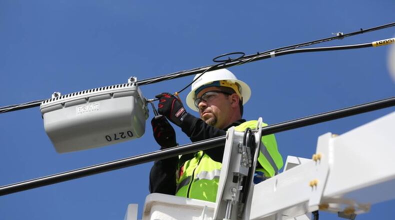 IMAGE DISTRIBUTED FOR COMCAST - A Comcast Network Technician works on an Xfinity WiFi hotspot on Lee Street in Des Plaines, Ill. Already the largest WiFi network, Comcast announced today that more than 325,000 WiFi hotspots have been installed in the Greater Chicago Region since Xfinity WiFi was launched here in May of 2013. In addition, the company announced today that the network will reach 8 million hotspots across the nation this year. (Comcast via AP Images)