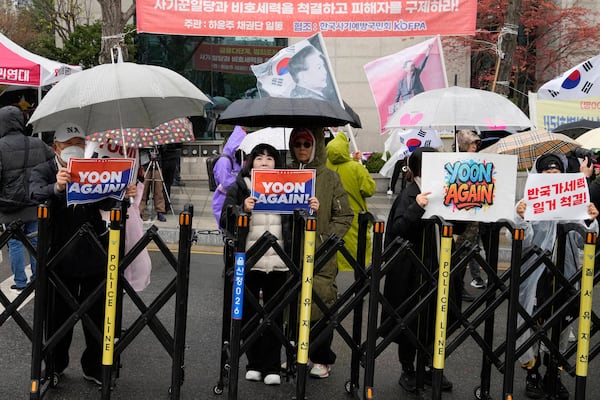 Supports of South Korea's ousted President Yoon Suk Yeol stand to call for the cancellation of his removal in front of the Seoul Central District Court in Seoul, South Korea, Monday, April 14, 2025. (AP Photo/Ahn Young-joon)