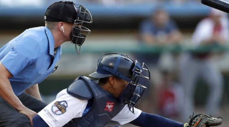 Home plate umpire Brian deBrauwere, left, crouches behind catcher James Skelton during the Atlantic League All-Star Game on Wednesday. The umpire wore an earpiece, which was connected to an iPhone in his baseball bag, to call balls and strikes.