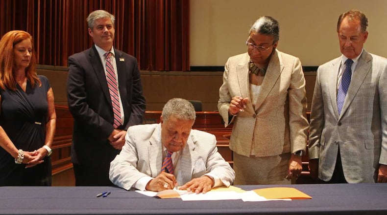 Robb Pitts, chairman of the Fulton County commission, signs a settlement agreement during a press conference at the Fulton County Government Center in Atlanta on Monday, July 22, 2019. Fulton County held a press conference to discuss their recent settlement with the Georgia Department of Revenue. The settlement was related to a proposal that could have caused homeowners to pay extra taxes because of frozen 2017 property values. (Christina R. Matacotta/AJC)