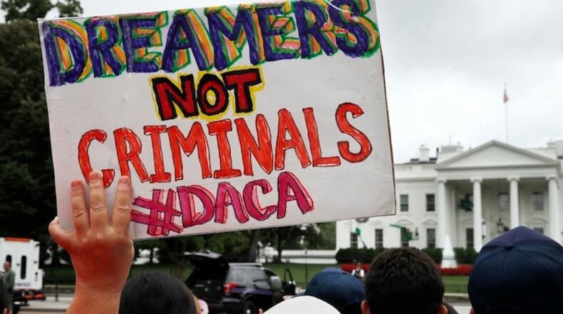 A woman holds up a signs in support of the Obama administration program known as Deferred Action for Childhood Arrivals, or DACA, during an immigration reform rally, Tuesday, Aug. 15, 2017, at the White House in Washington. The Trump administration has said it still has not decided the program's fate. (AP Photo/Jacquelyn Martin)