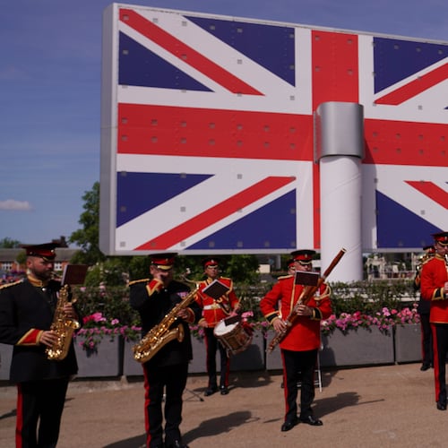 A military band plays in front of a large British flag shown on an electronic display on the second day of the Royal Ascot horse race meeting at Ascot, England, Wednesday, June 18, 2025. (Alberto Pezzali/AP)