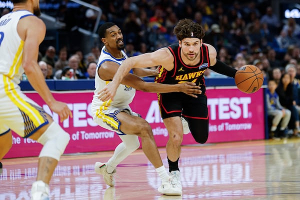 De'Anthony Melton (center) of the Golden State Warriors guards Corey Kispert (right) of the Atlanta Hawks during the fourth quarter of an NBA basketball game in San Francisco, Sunday, Jan. 11, 2026. (Carlos Avila Gonzalez/San Francisco Chronicle via AP)