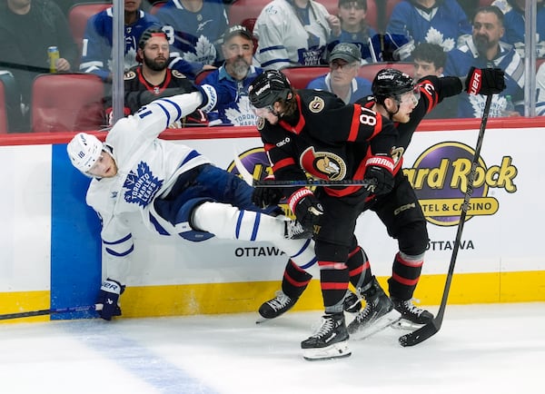 Ottawa Senators' Adam Gaudette (81) battles with Toronto Maple Leafs' Steven Lorentz (18) along the boards during third period NHL playoff action in Ottawa, Saturday, April 26, 2025. (Adrian Wyld/The Canadian Press via AP)